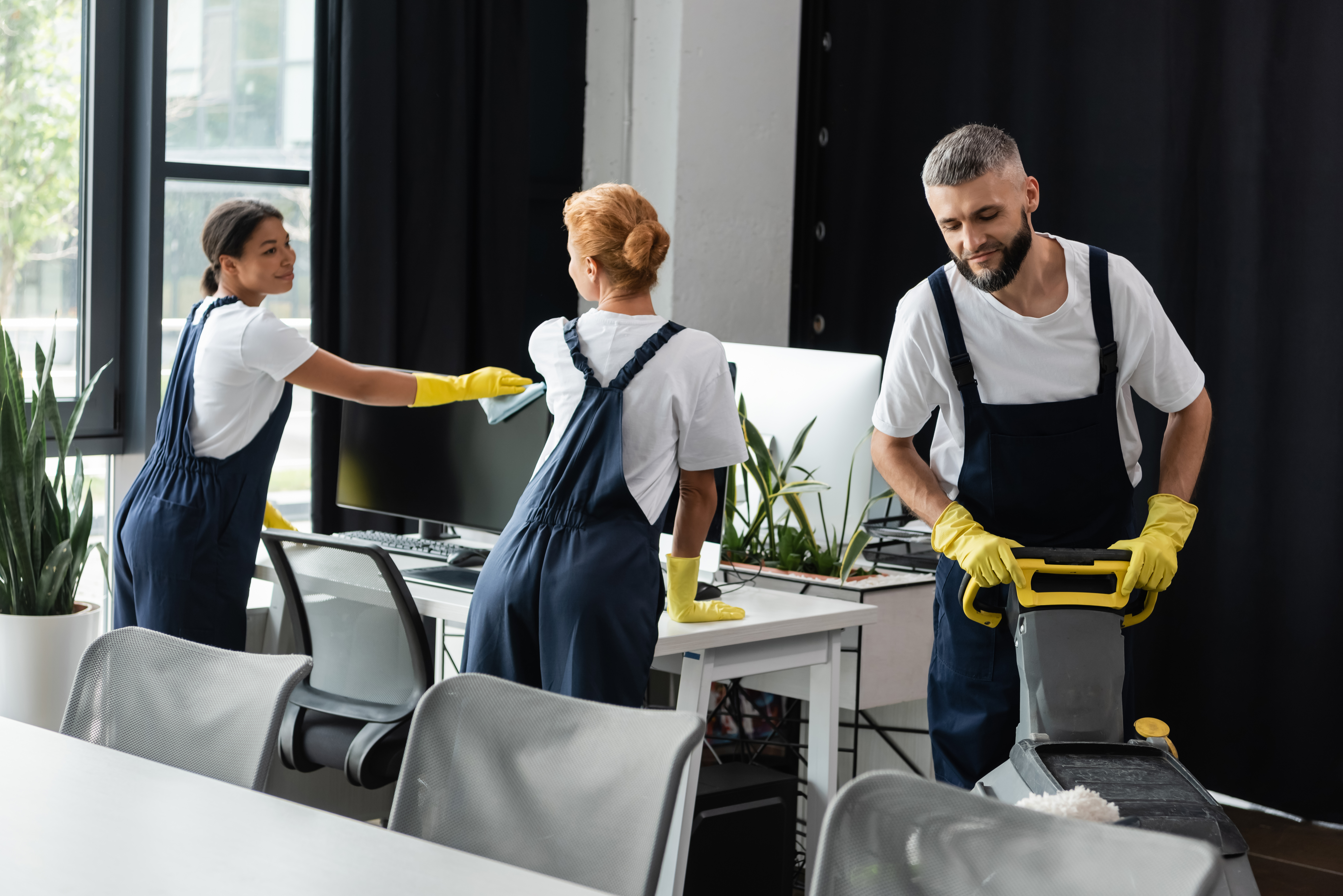süd.cleaning Team bei der Büroreinigung — drei Mitarbeitende in Arbeitskleidung